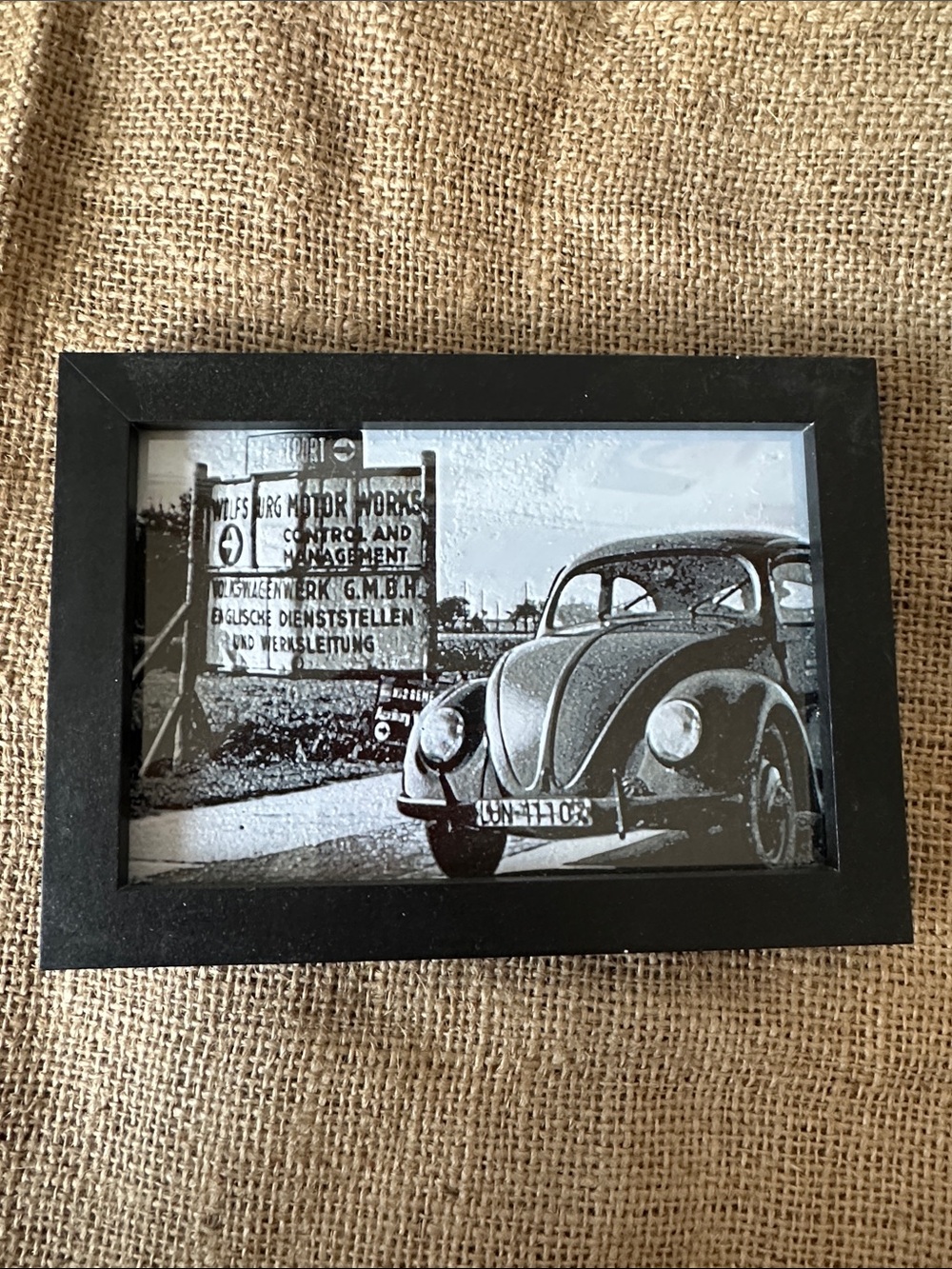 framed image of a vw beetle leaving the factory in germany 3d printed , framed